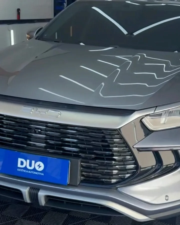 Sedã prata na cabine da DUO com reflexos das luzes na pintura